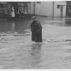 Man in flooded high street A villager struggles against the force of the flood, walking down the High Street