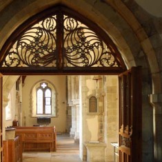 South_aisle_with_door_arch Woodwork over the doorway to the Lady Chapel, also the design of Ninian Compler