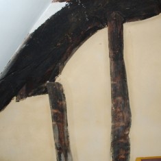 Truss beam from bedroom. Truss beam seen from a bedroom on the other side of the wall. This was revealed in 2009, and is deemed to be fine by the standards of carving in the early 14th century.