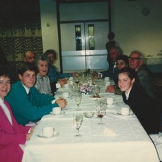 Colour photo Reg Files (on right, with grey hair, leaning back) with villagers at Village Hall event