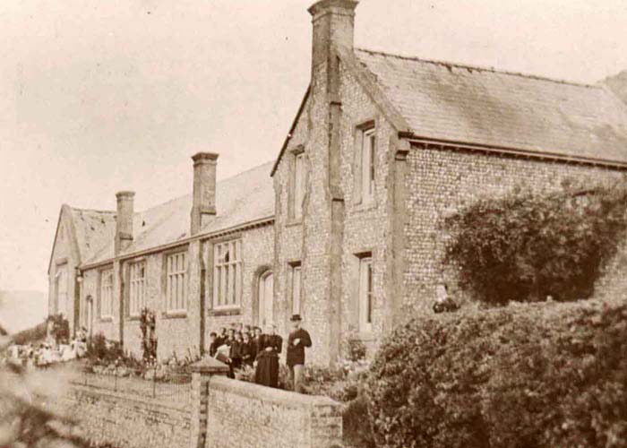 Groups of girls and boys outside their entrances to East Meon National School, 1900. William S. Tregear, headmaster, on the right.