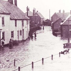 Barnards and War Memorial flooded. Hazel Goddard is standing on the doorstep