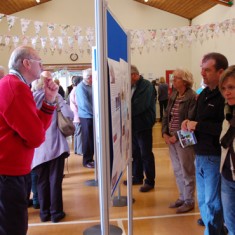 Panels and bunting with crowds Visitors examining the House History screens.