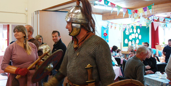 Saxons blowing horn and beating drum to summon visitors to witness the re-enactment.