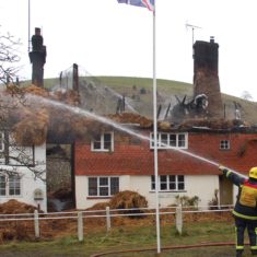 Firemen with hose 2 Firefighters and appliances after the first fire at Brook and Hockley cottages, March 2009.