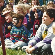 Kids watching, one with painted face Kids watching arena event one with painted face